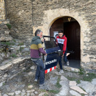 Els artistes de l'exposició 'Tradicions i contradiccions' retirant els peces de la mostra de l'interior de l'església de Farrera.