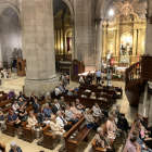 Desenes de persones van accedir a l’altar de la Moreneta durant la missa celebrada a la Catedral.