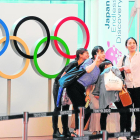 Viajeros haciendo fotos junto a los aros olímpicos, a su llegada al aeropuerto de Tokio.