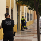 Dos operarios limpian la puerta del colegio de Málaga frente a la cual  se cometió el crimen.