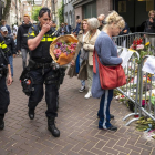 Una policía se dispone a dejar flores donde fue tiroteado De Vries.
