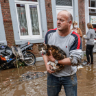 Un hombre sostiene un gato en la ciudad belga de Pepinster.