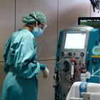 Un malalt és atès per una infermera a l'UCI de Vall d'Hebron.
