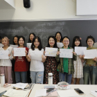 Tretze de les catorze estudiants xineses que han vingut aquest any posen amb uns cartells en xinès fets per elles que diuen “Hola, Lleida!”.