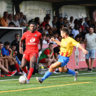 Un jugador de l’Alpicat prova d’avançar davant de la pressió d’un jugador rival.