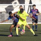 Un jugador del Tàrrega pugna amb un adversari pel control de la pilota durant una situació del partit.