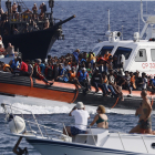 Turistes davant de migrants rescatats a Lampedusa, a Itàlia.