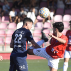 Ángel Fernández, jugador de l’Atlètic Lleida, refusa una pilota de cap davant d’Álex Sánchez.