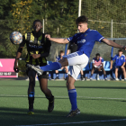 Un jugador del Lleida B refusa l’esfèric dins del cercle central davant la pressió d’un rival.