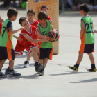 Un grup de nens juguen un partit de bàsquet.