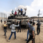 Milicians palestins prenen el control d’un carro de combat israelià al travessar la frontera de Gaza.