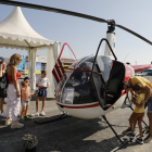 Visitants davant d’un helicòpter en exposició ahir a la fira aeronàutica de l’aeroport d’Alguaire.