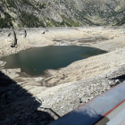 El llac natural que ha quedat al descobert per les obres a la presa de Cavallers.