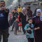 Famílies palestines fugen de les seues llars després que l’exèrcit israelià ataqués un edifici de la ciutat de Gaza.