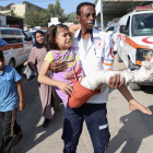 Un sanitari trasllada una nena ferida al pas de Rafah.