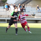 Un futbolista de l’Almacelles forceja amb un rival per intentar emportar-se la pilota.