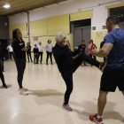 Una veïna practica amb l’instructor del taller un dels moviments apresos ahir.