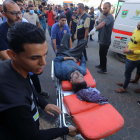 Diversos sanitaris traslladen un ferit després d’un atac israelià a Deir al-Balah, a la Franja de Gaza.