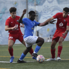 Un jugador de l’Alcarràs s’intenta escapolir de dos oponents de l’Alpicat.