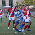 Un jugador local controla la pilota amb el pit, pressionat pel capità de l’Artesa de Lleida.