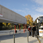 Diverses persones pujant ahir a un autobús en el primer dia de funcionament de l’estació de Juneda.