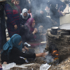Famílies palestines desplaçades fan pa en un forn de llenya en un camp de refugiats a Rafah.