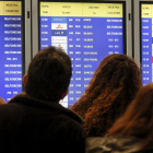 Foto d’arxiu de viatgers davant d’un plafó informatiu a Barajas.