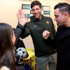 Sergi Roberto i Xavi, al costat d’una nena durant la visita d’ahir.