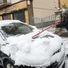 Un veí d’Esterri d’Àneu, retirant ahir la neu acumulada durant la nit al seu vehicle.