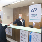 Un treballador de l’hospital Arnau de Vilanova de Lleida entregant una mascareta a una usuària.