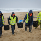 Operaris de neteja retiren els pèl·lets de plàstic en una platja d’O Vilar, a la Corunya.