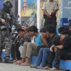 Un policia custodia membres d’un grup armat a Guayaquil.