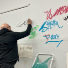 Gerada va firmar a la paret de l’aula amb autògrafs d’altres artistes.