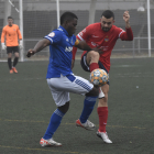 Un jugador del Lleida B lluita per la pilota davant d’un del Balaguer.