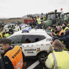 Un grup d’agricultors empeny un cotxe de la Guàrdia Civil que els impedia entrar amb els tractors en una carretera de Navarra.