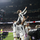 Luka Modric, acompanyat pels seus companys, celebra el gol del triomf sobre una tanca publicitària.