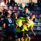 Àngel i Bayu, de l’Atlètic Lleida, pugnen per una pilota amb dos rivals.