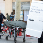 Els serveis funeraris retiren el cos sense vida de la dona assassinada pel seu fill a Barcelona.