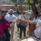 Alguns dels assistents al vermut fent un brindis (esquerra) i la presidenta de L’Olivera, Dolors Llonch, amb l’autor del mural (dreta).