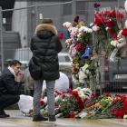 Una família russa deixa flors en un memorial als morts en l’atemptat a la capital de Rússia.