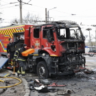 Dos bombers ucraïnesos, al costat d’un camió calcinat per un míssil a Khàrkiv.