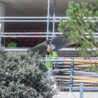 Un treballador de la construcció transporta material.