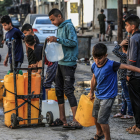 Palestins, inclosos nens, fan cua amb contenidors d’aigua potable per omplir-los a Rafah.