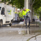 Un operari neteja la vorera de Ronda amb aigua a pressió.