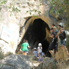 Un grup d’adults i nens, abans d’entrar a la Cova dels Muricecs després de reobrir al març.