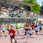 Una cursa femenina passant per davant de la grada plena de públic.