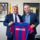 Hansi Flick posa amb Joan Laporta subjectant una samarreta del Barça amb el seu nom imprès.