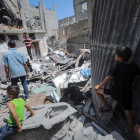 Palestins busquen desapareguts sota la runa d’una casa destruïda arran d’un atac aeri.