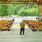Guardiola, amb els participants del Pep Summer Camp de fons a la pista annexa al camp de futbol de Rialp.