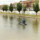 Una barca especial opera aquesta setmana en el tram urbà del Segre a Balaguer per eliminar algues.